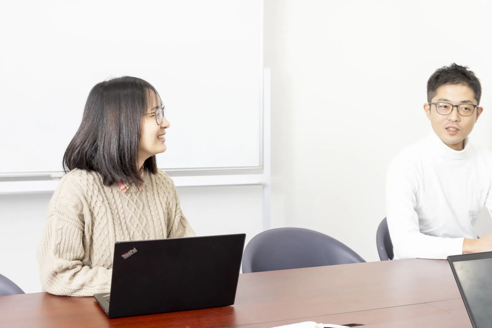 会議室でノートPCを前に話し合うメンバー
